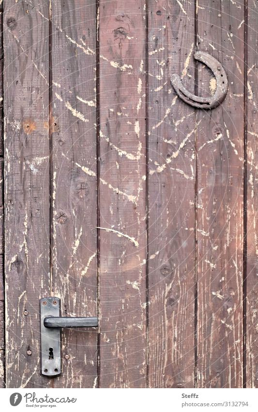 old times with wood and iron Superstition Wooden door Front door Protection Popular belief Horseshoe Happy symbol Iron shed door Entrance Door lock Weathered
