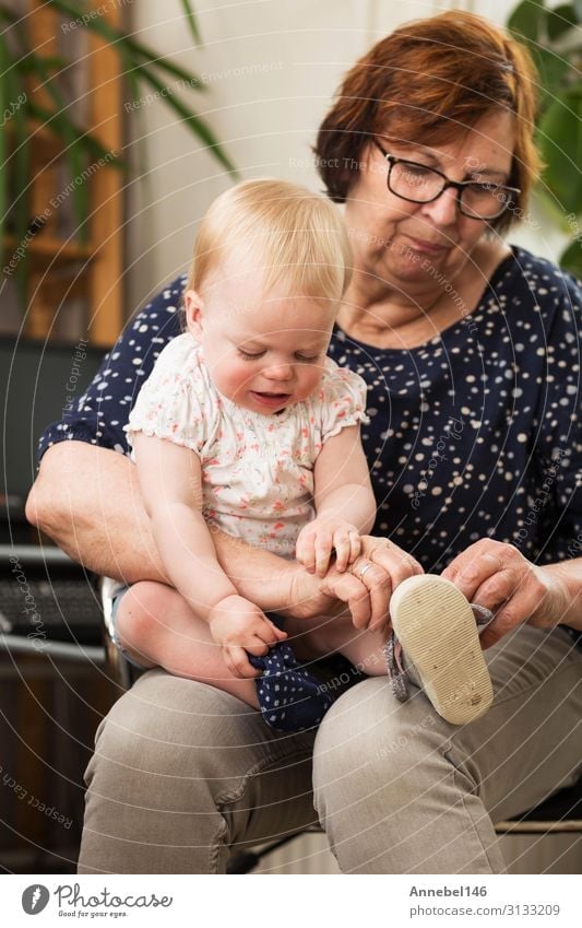 Grandmother and grand daughter, puts on a shoe on her lap Joy Happy Playing Child School Baby Toddler Grandfather Family & Relations Old To enjoy Smiling Love
