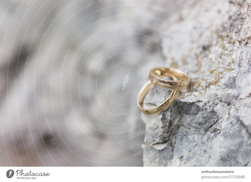 Golden wedding rings on a rock Lifestyle Shopping Elegant Happy Wedding Rock Stone wall Stony Ring Precious stone Spring fever Trust Infatuation Romance