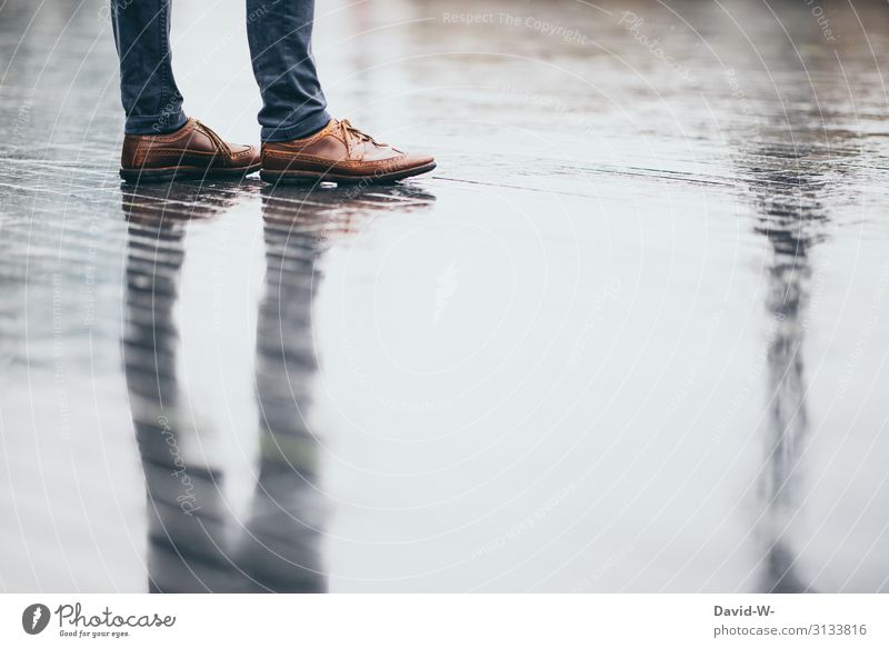 Man stands with reflection on the wet street in rainy weather mirror Shadow Wet Rain Rainy weather Autumn Autumnal Reflection Colour photo Drops of water