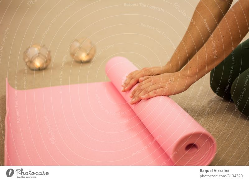Woman's hands rolling up a pink yoga mat. Lifestyle Body Skin Health care Wellness Relaxation Meditation Spa Massage Sports Yoga Human being Adults Hand 1 Brown