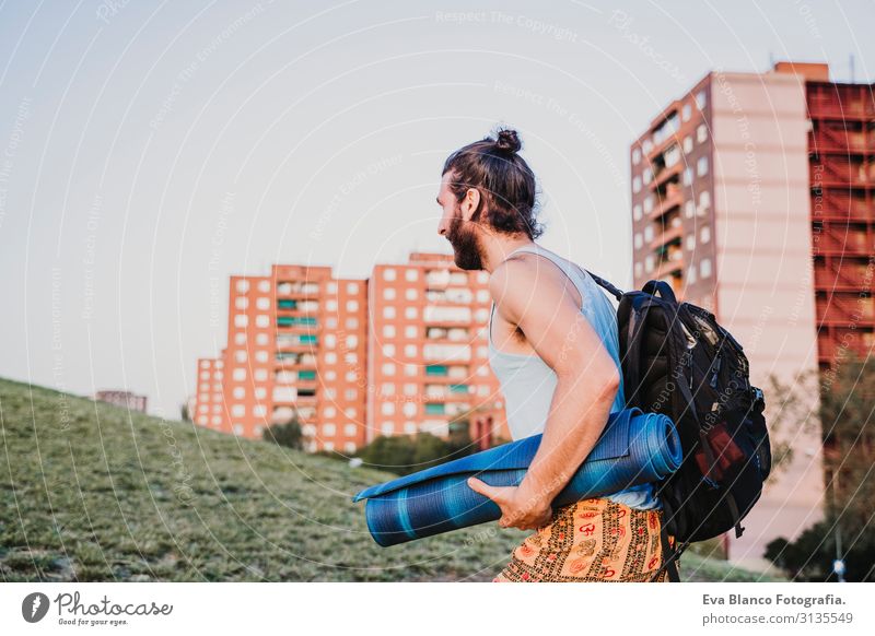young man in a park ready to practice yoga sport. city background. healthy lifestyle Concentrate Position Human being Youth (Young adults) Body Park Man