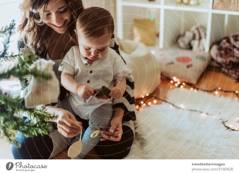 Mother and baby playing around the Christmas tree Family Baby Latin hispanic luck New Year Child Daughter Public Holiday Woman celebration mama Room Home
