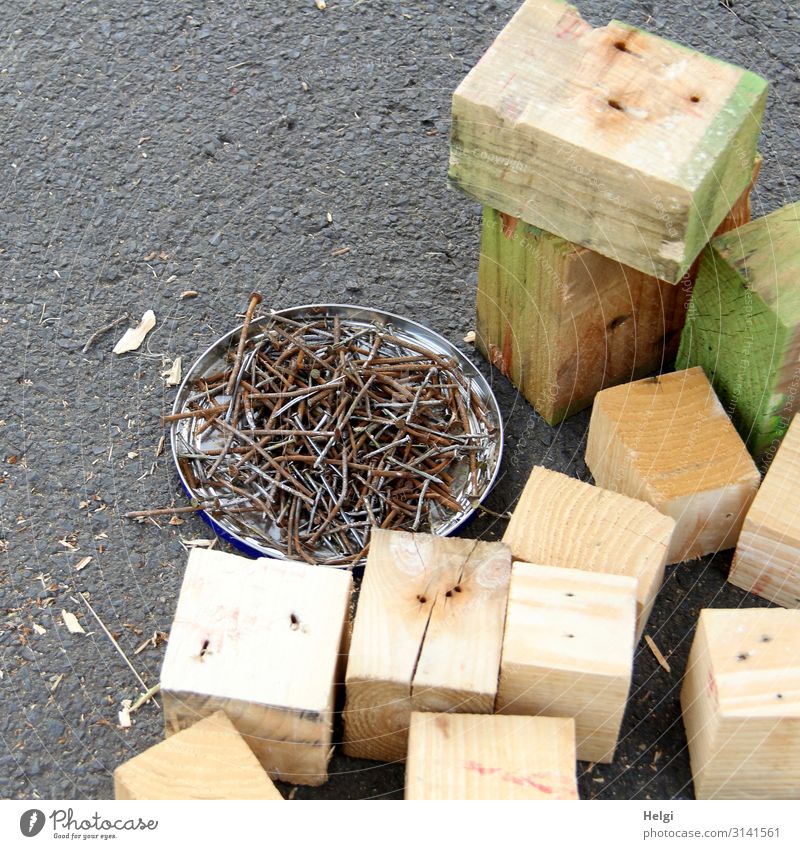 Wooden blocks and many old nails lie on asphalt Metal Work and employment Lie Stand Authentic Sharp-edged Brown Gray Green Determination Beginning Effort