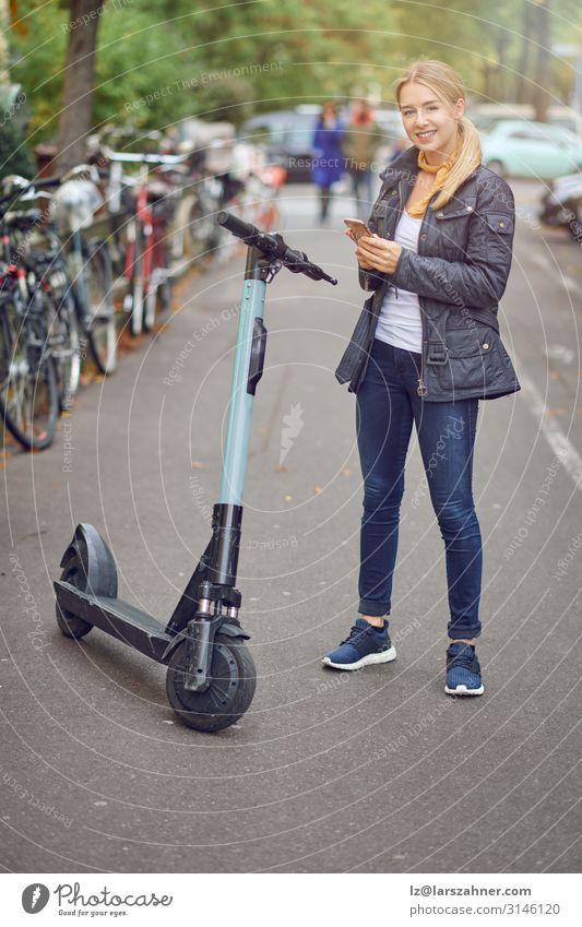Young blond woman standing near electric kick scooter Lifestyle Happy Beautiful Leisure and hobbies Technology Woman Adults 1 Human being Transport Blonde Stand