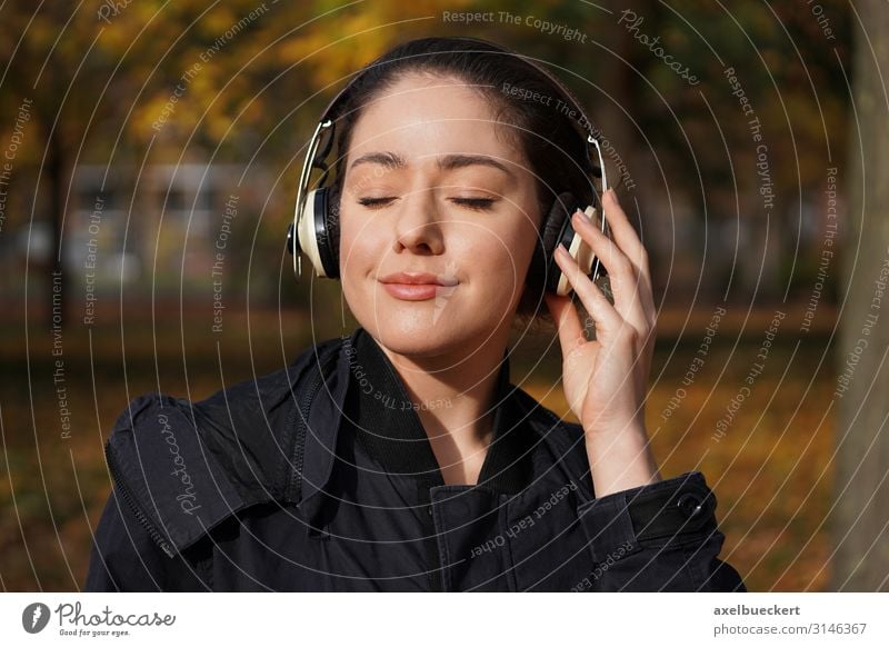 young woman listens to music through headphones outside Lifestyle Joy Leisure and hobbies Entertainment Music Technology Entertainment electronics Human being
