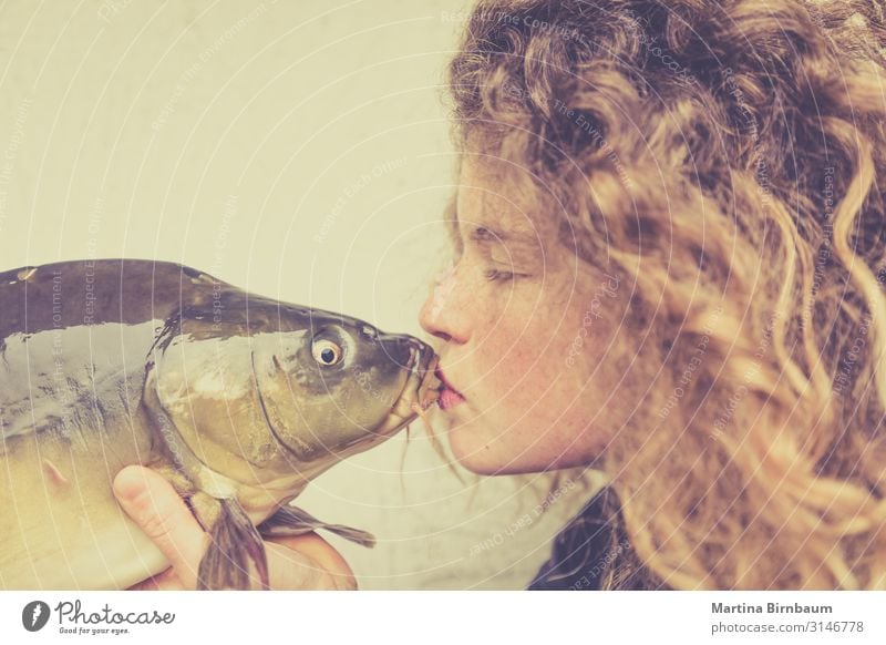 Young woman kissing a carp, fish Seafood Dinner Diet Lifestyle Happy Beautiful Face Human being Feminine Woman Adults Mouth Lips Animal Kissing Love Stand