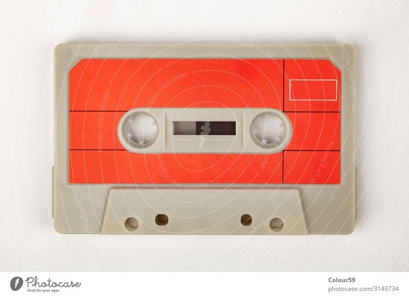Music cassette with red label Tape cassette Retro audio 80s Disco Background picture Analog Audio tape Iconic Listen to music Colour photo Bird's-eye view