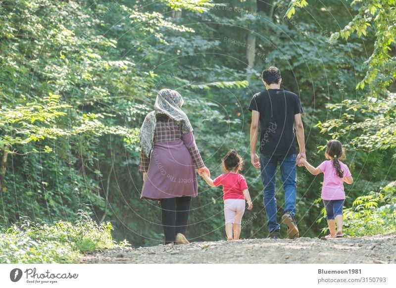 Backside of young family walking together outside in green nature Lifestyle Relaxation Vacation & Travel Summer Parenting Child Human being Girl Young woman