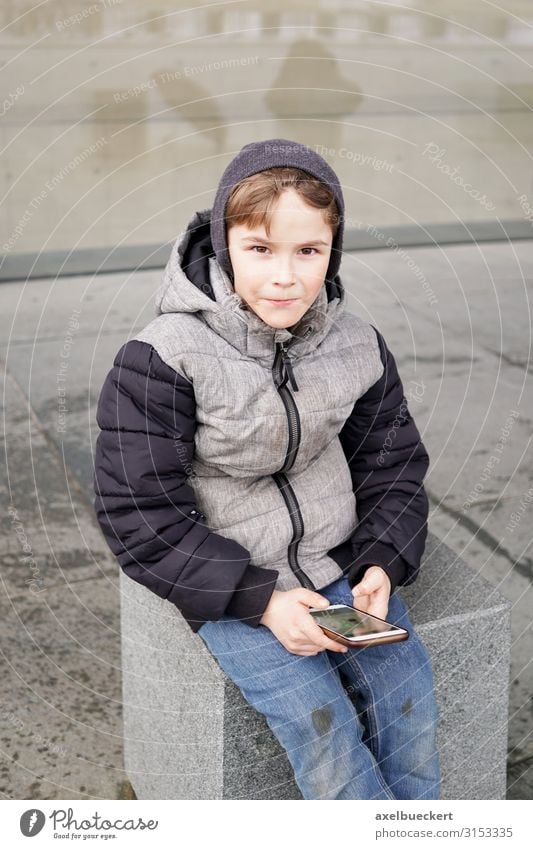 Boy with Smartphone Lifestyle Leisure and hobbies Playing Winter Child School Schoolyard Telephone Cellphone PDA Technology Internet Human being Boy (child)