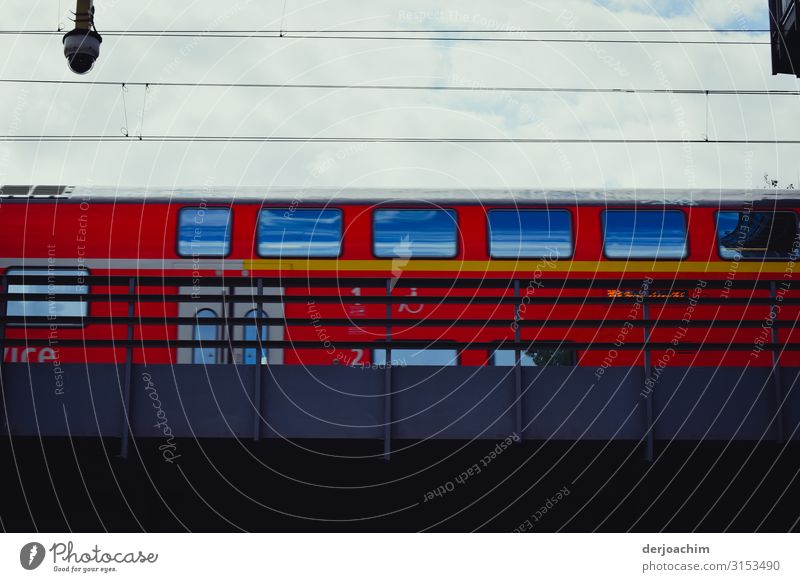 Train service. A train speeds over a bridge. The train in red with blue windows. Joy Trip Industry Summer Beautiful weather Railroad tracks Berlin Germany