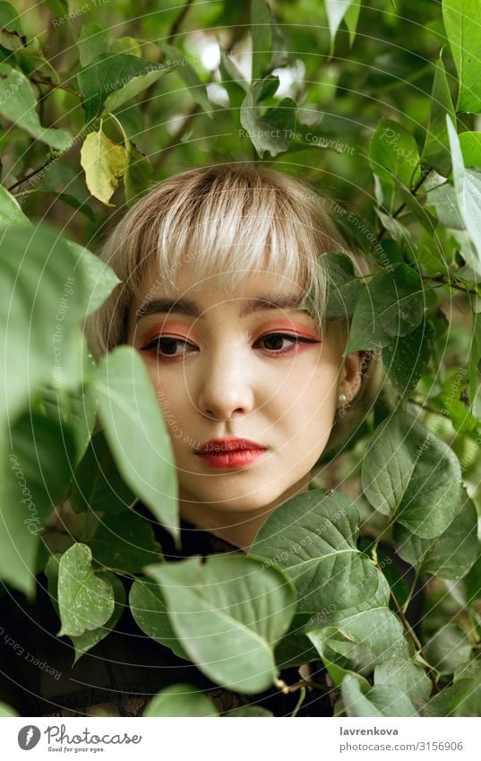 Asian female in green leaves, shallow selective focus Asians Blonde Close-up Eyes Face Woman Young woman Hand Lifestyle Park Human being Youth (Young adults)