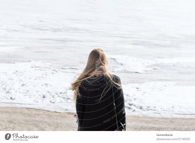 Back of the young woman standing on the frozen river Faceless Loneliness Coast Beach Snow Ice Cold Vacation & Travel Blonde Hair Winter Human being Lifestyle