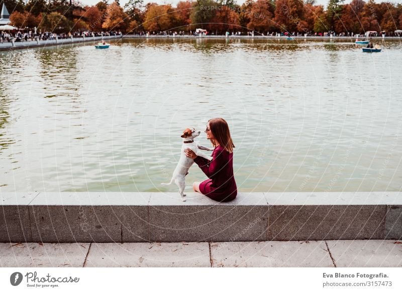 young woman and cute dog by the lake in an urban park. Love for animals concept. Retiro park Madrid Woman Dog Pet Lake Park Exterior shot City Embrace Together