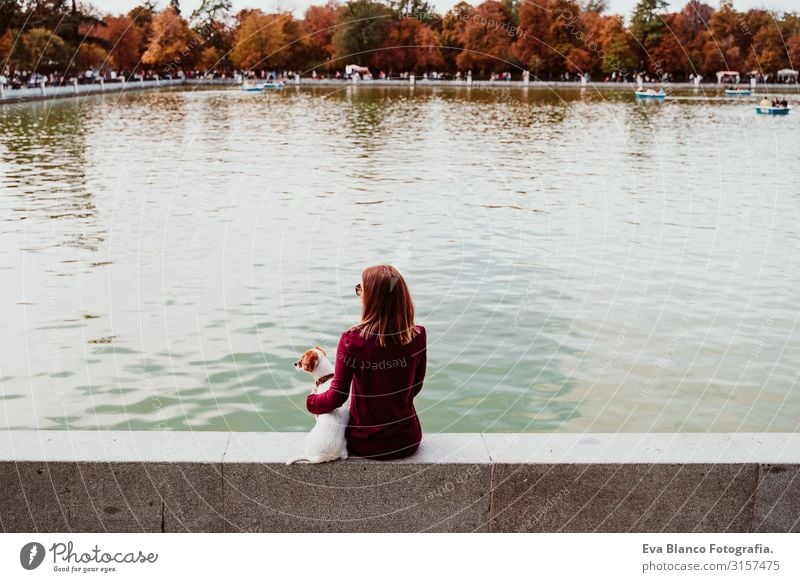 young woman and cute dog by the lake in an urban park. Love for animals concept. Retiro park Madrid Woman Dog Pet Lake Park Exterior shot City Embrace Together