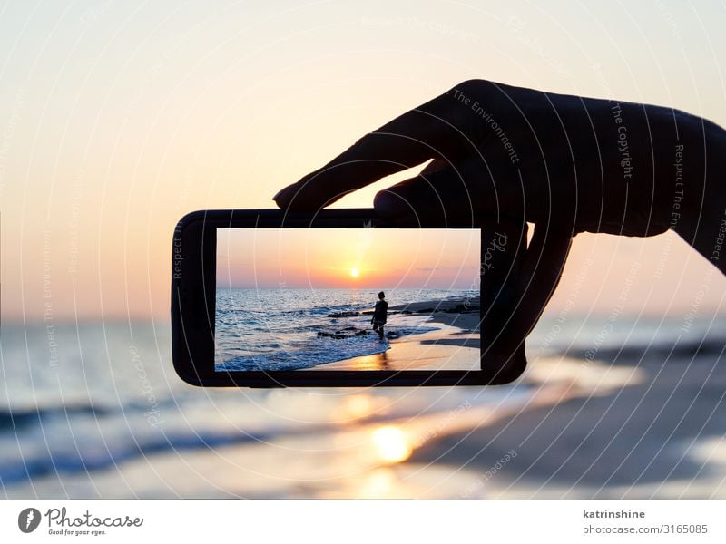 Man takes a sunset photo on the phone Vacation & Travel Summer Beach Ocean Cellphone PDA Technology Woman Adults Hand Environment Nature Landscape Sky Dark Blue