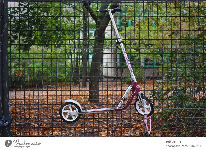 Connected scooter Parking lot Relaxation Keep Border Autumn Hang Kindergarten Wire netting fence Deserted Scooter School building Schoolyard Copy Space Fence