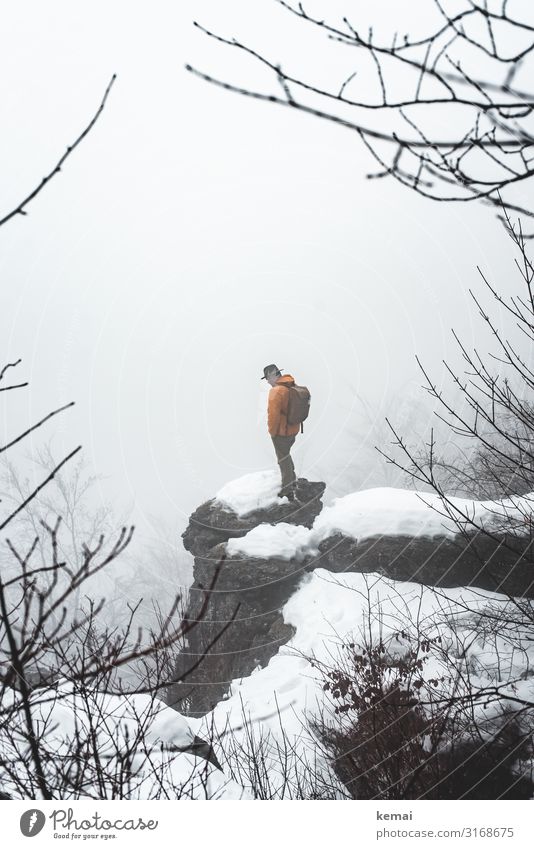 A man and a rock Lifestyle Well-being Contentment Senses Calm Leisure and hobbies Trip Adventure Freedom Winter Snow Winter vacation Hiking Human being