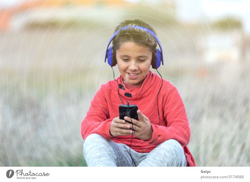 Child with dark hair listening music Joy Happy Beautiful Face Music Telephone PDA Human being Infancy Nature Landscape Fashion To enjoy Listening Smiling