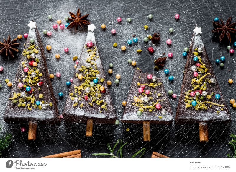 four Christmassy decorated Christmas trees made of chocolate cake with sugar pearls, star anise and cinnamon sticks Cake Christmas & Advent fir tree Food Dough