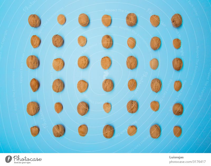 Nuts and almond on blue background Design Autumn Warmth Brown Yellow almonds Dried fruits food health nuts Consistency walnut Abstract Pattern
