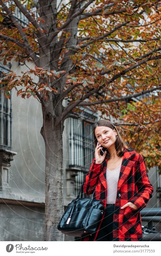 pretty young woman walking on the street using smartphone cell technology smile daylight looking away device gadget conversation outdoors city tail cheerful