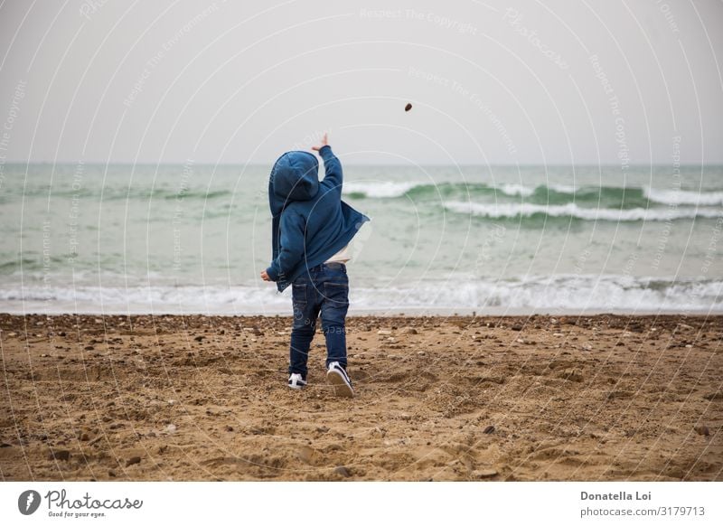 Child throws a stone in the sea Life Playing Beach Ocean Waves Winter Human being Masculine Infancy Body 1 1 - 3 years Toddler Autumn Jeans Stone Sand Blue