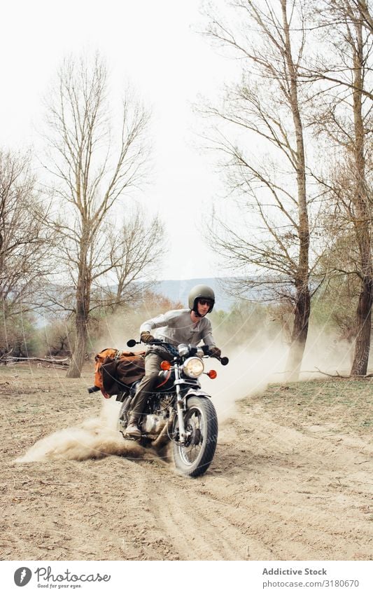 Man riding motorcycle on dusty road Motorcycle Ride Nature Vacation & Travel Tree Leafless Dust Landscape Trip Transport Vehicle Drive Freedom Lifestyle