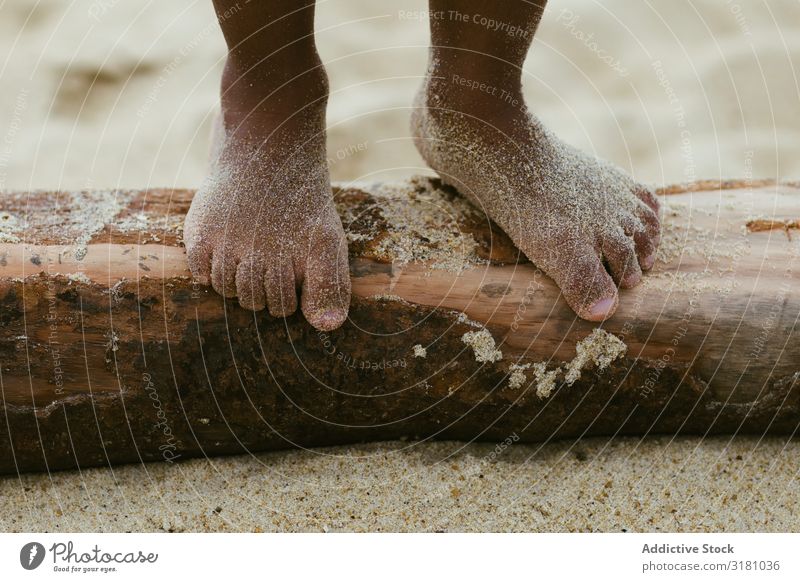 Anonymous black kid walking on log Child Legs Walking Log Sand Summer Beach Barefoot Small Wet Lifestyle Leisure and hobbies Rest Relaxation Black Ethnic