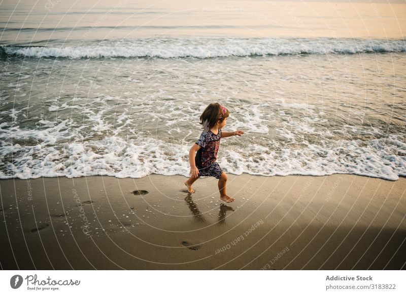 Child going in sea on coast Ocean Coast Girl Water Foam Sand Splash Funny Going Beach Joy Happiness Summer Nature Leisure and hobbies Action Swimming Playing