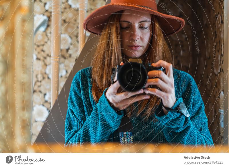 Young female taking pictures at home Woman Home Photography Professional Camera Mirror Expressive Youth (Young adults) Red-haired Beautiful Modern Sweater Hat