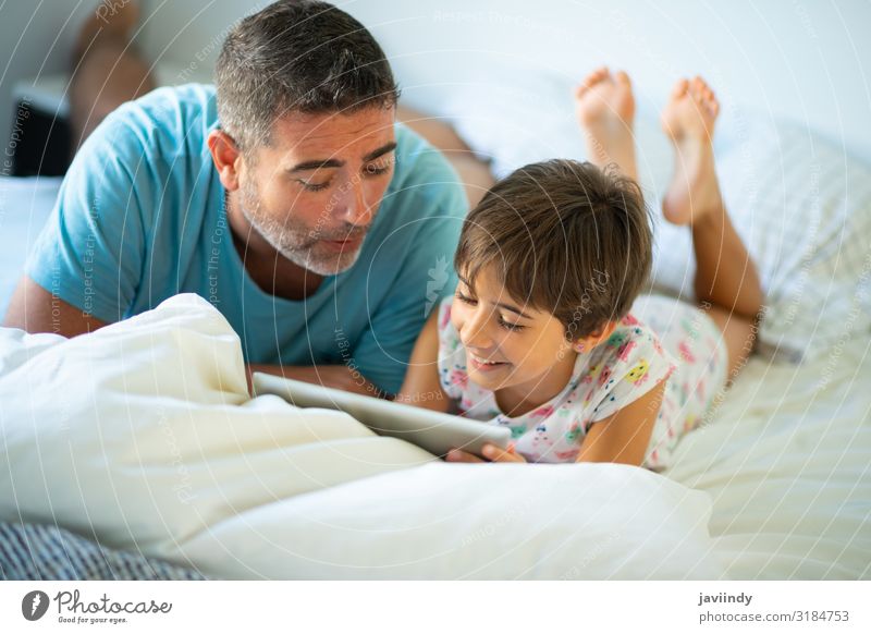 Father with eight years daughter using digital tablet Lifestyle Happy Beautiful Leisure and hobbies Playing Bedroom Parenting Child Computer Technology Internet