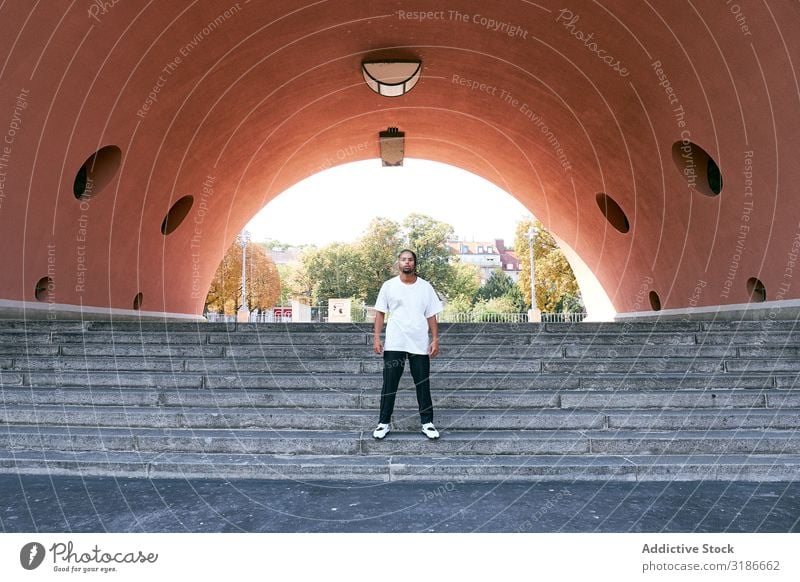 Trendy black guy posing near modern arch Man Arch Street Modern Looking into the camera African-American Fashion fashionable Self-confident Youth (Young adults)
