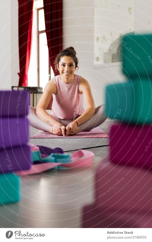 Woman sitting among sports equipment in studio Equipment Studio shot Yoga Sit Sports Brunette Thin Mat Sportswear Pink Multicoloured Attractive Flexible pose