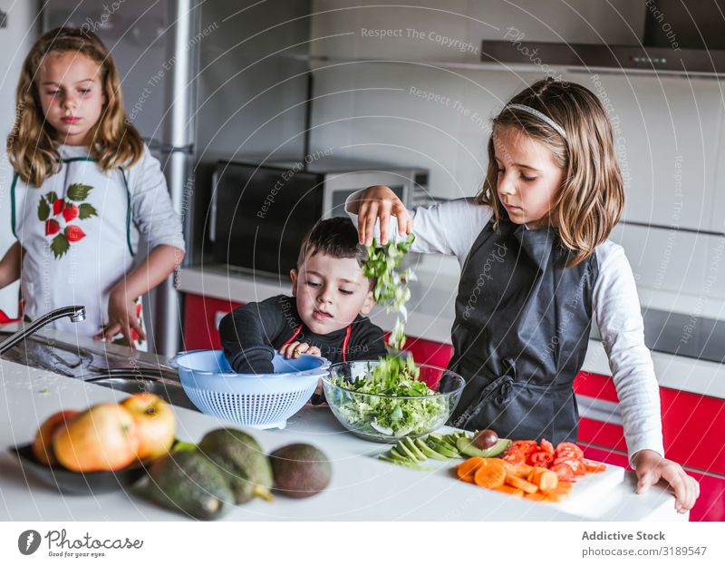 Kids playing while preparing vegetables for salad siblings Vegetable Kitchen Cooking Peeling cutting Salad Home Girl Boy (child) Vegan diet Healthy Fresh Child