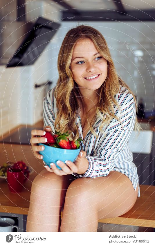 Young seductive female eating strawberry in kitchen Woman Eating Strawberry Bowl Eroticism Table Sit Kitchen Youth (Young adults) Beautiful Attractive pretty