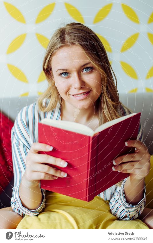 Young happy female reading book on sofa Woman Reading Book Eroticism Smiling Happy Youth (Young adults) Joy Cheerful Beautiful Attractive pretty Charming