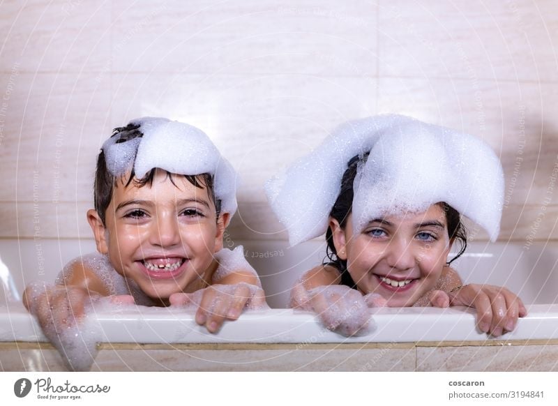 Two kids taking a bath looking a camera Lifestyle Joy Happy Beautiful Personal hygiene Hair and hairstyles Skin Swimming & Bathing Children's game Bathtub