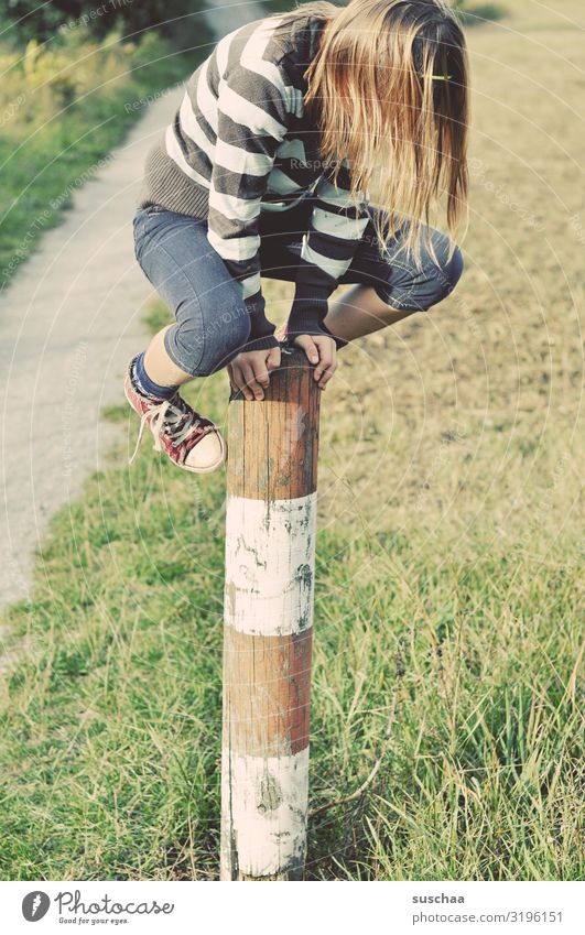 climber Child Girl boyish Climbing Playing Reckless Pole Wooden stake Fence post To hold on Exterior shot Footpath Nature Romp Infancy Dexterity Lanes & trails