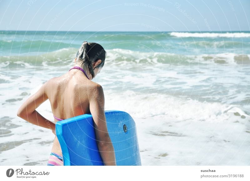 girl in a bikini standing from behind in front of the rough sea with a surfboard under her arm Child Bikini vacation holidays Summer Water Ocean Beach