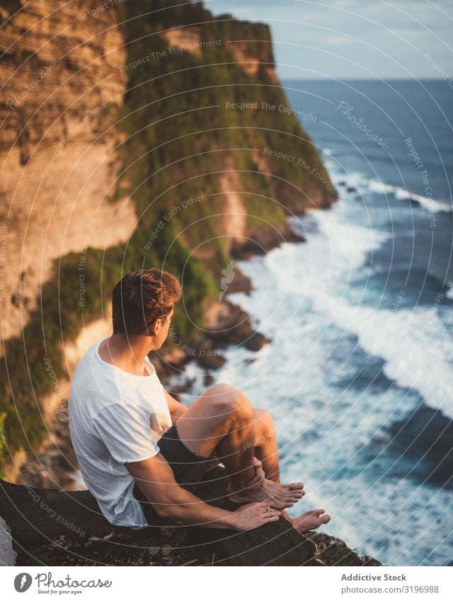 Traveler on high cliff viewing ocean Man Cliff Ocean Observe Height Vantage point Bali Nature Rock Water Altimeter Vacation & Travel Adventure Majestic Sit