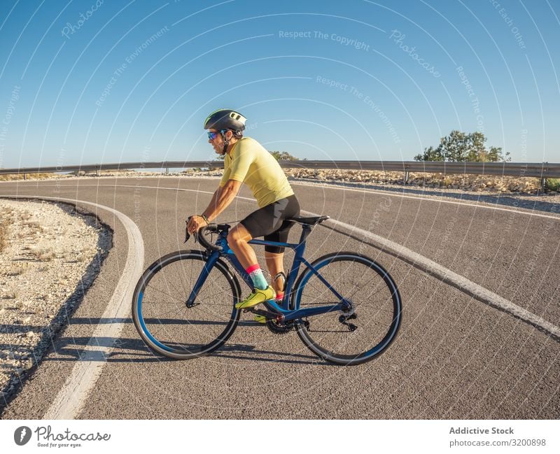 healthy man riding a bicycle on a mountain road in a sunny day Leisure and hobbies Athlete Sports Ride Bicycle Racing sports Man Motorcycling Exterior shot