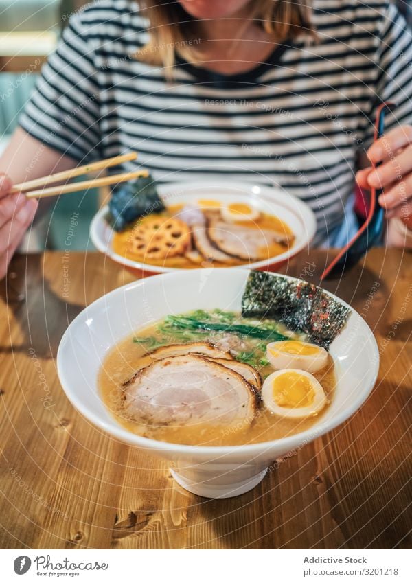 Female eating Japanese dish Woman ramen Soup Dish Bowl asian Food Tradition Lunch Dinner Human being Adults Eating Sit Hold enjoying Cooking Restaurant Meat Egg