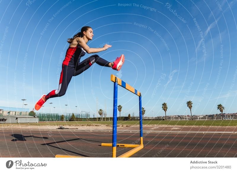 Female athlete hurdling on stadium Woman Hurdle Jump Stadium Sports Track Youth (Young adults) Sportswear Sky Blue Competition Athlete Determination motivation
