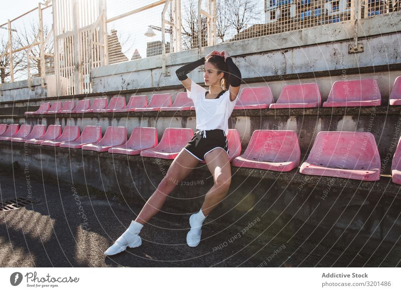 Young sportswoman resting on shabby seat Woman Stadium Fitness Break Sit Ocean grungy Rest Youth (Young adults) Sportswear facility Shabby Weathered Relaxation