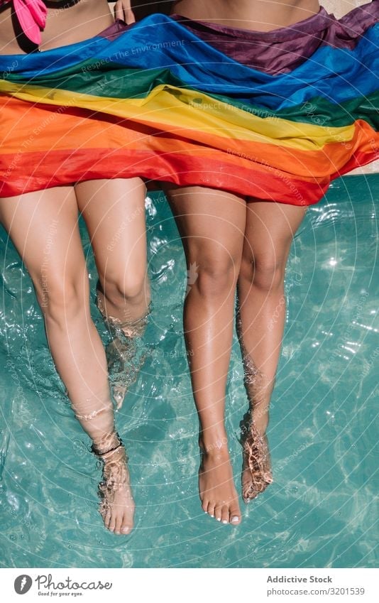 Crop lesbian couple sitting on poolside Couple lesbians Swimming pool Sit Legs lgbt Flag Barefoot Youth (Young adults) Woman Resort Vacation & Travel