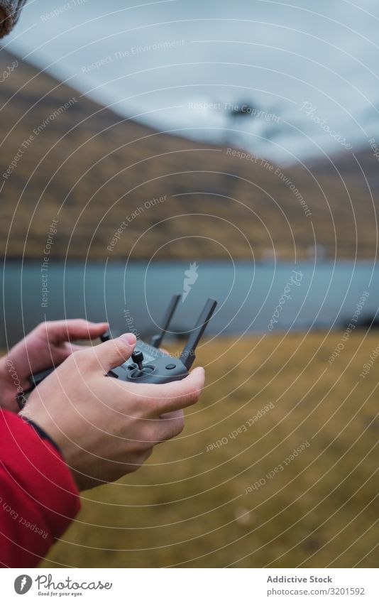 unrecognizable person controling drone near lake in Faroe island Remote Technology Testing & Control Drone innovation Radio (broadcasting) Camera Hand Antenna