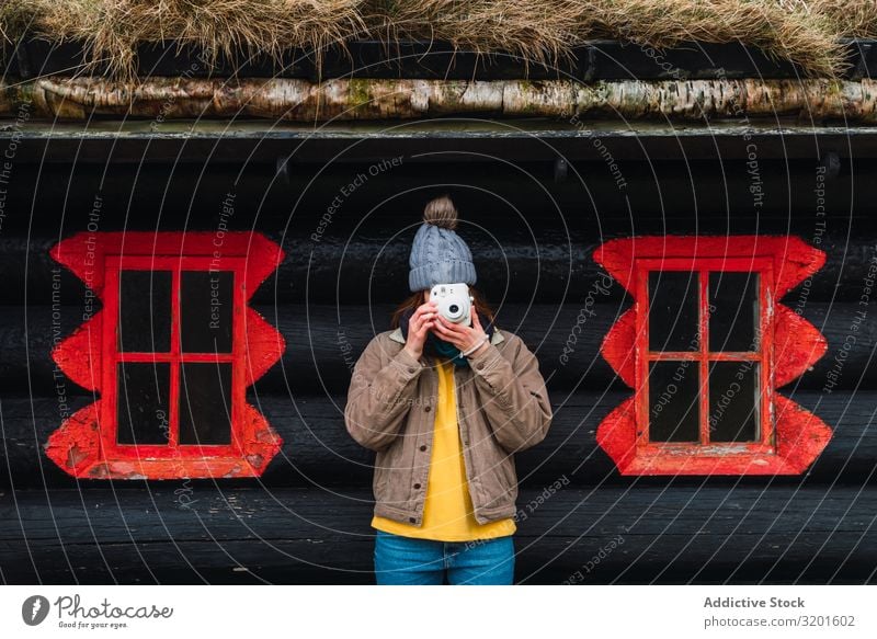 woman wearing winter clothes in front of a wooden cabin taking photo Attractive Joy Happy Photography Mountain Happiness Portrait photograph Caucasian Camera