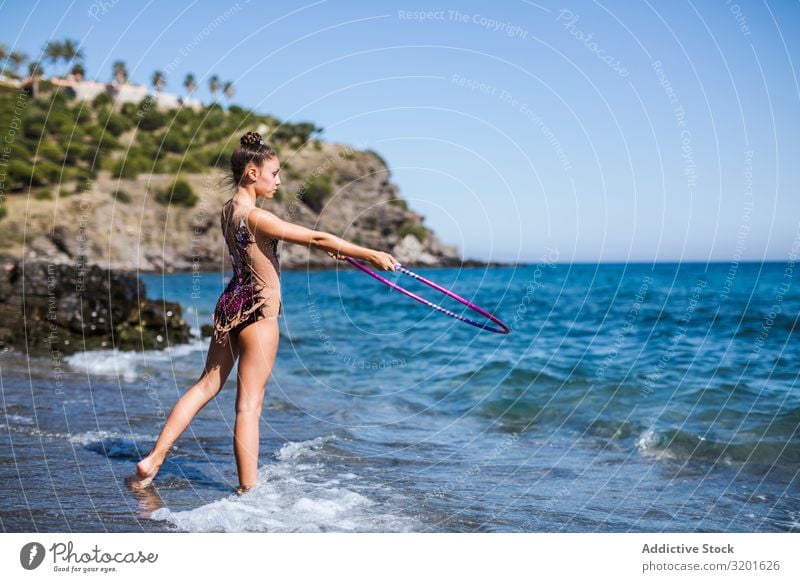 Graceful acrobat performs with hoop on beach Gymnast Woman rhythmic String Athlete Practice Gymnastics Sports Youth (Young adults) Human being Athletic artistic