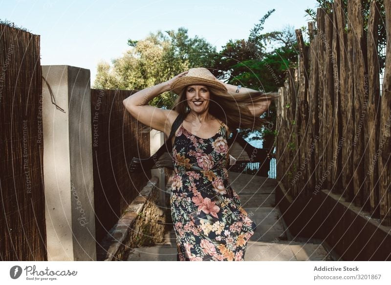 Cheerful woman in summer dress spinning around Woman Summer Dress Happy Adults Movement Vacation & Travel Straw hat Style Bright Tourism Emotions Expression